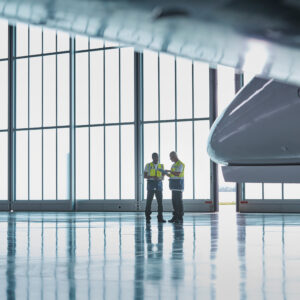 Air traffic control ground crew workers talking in airplane hang